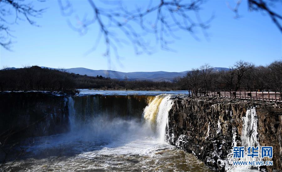 冬場では珍しい水しぶきを上げ流れ落ちる鏡泊湖吊水樓瀑布　黒竜江省