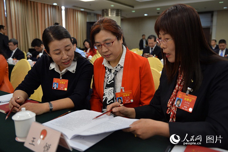 3月5日、遼寧代表団全體會議で、女性の代表が政府活動報告について意見を交換していた。（撮影：翁奇羽）