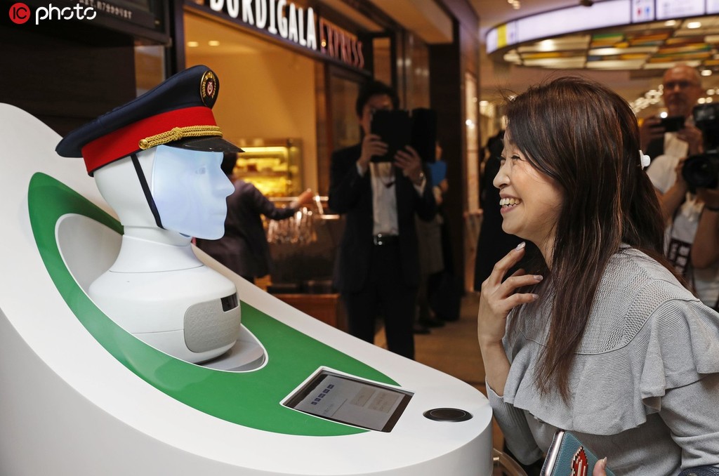 案內ロボットの「セミ」に駅構內などの案內をしてもらう乗客（寫真著作権は東方ICが所有のため転載禁止）。