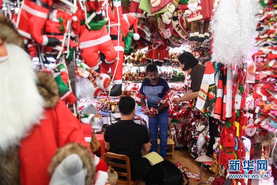 6月26日、義烏國際商貿城のある店でクリスマスグッズを仕入れるインド人バイヤー（寫真中央、撮影?黃宗治）。