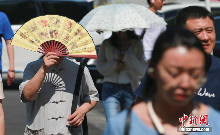 様々な日焼け対策をして外出する市民（撮影?賈天勇）。  