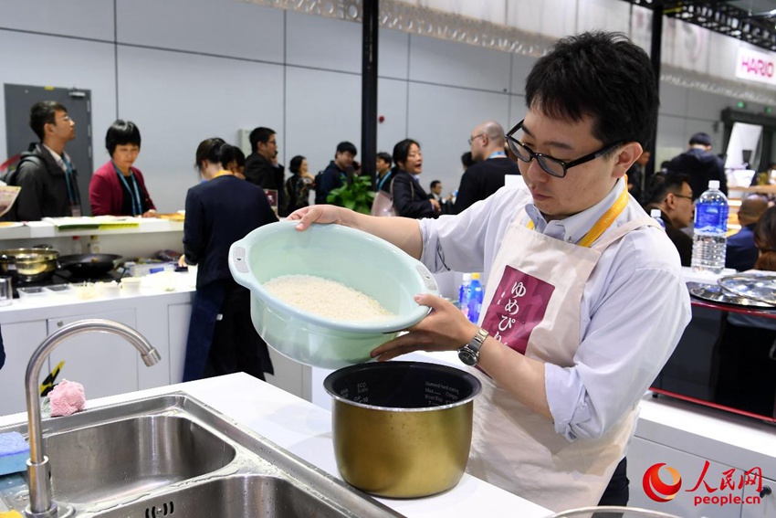 研いだ米を炊飯器に移す石山さん。