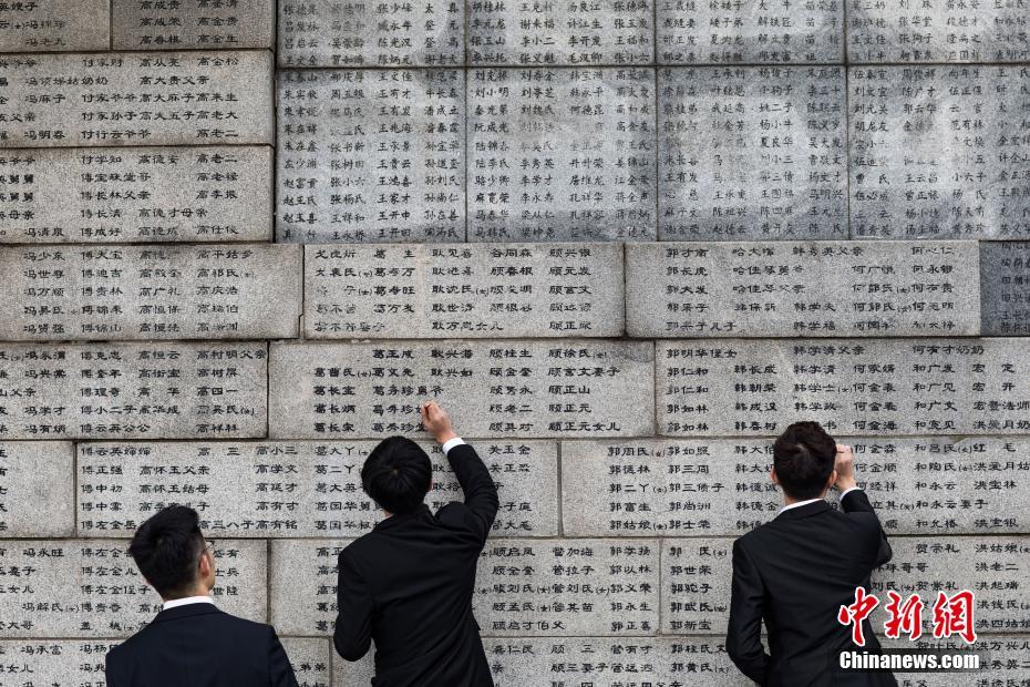 中國(guó)侵略日本軍南京大虐殺の犠牲者名が刻まれた壁で、犠牲者の名前を一つ一つ「書(shū)き直し」ていく南京審計(jì)大學(xué)のボランティア（撮影?泱波）。 