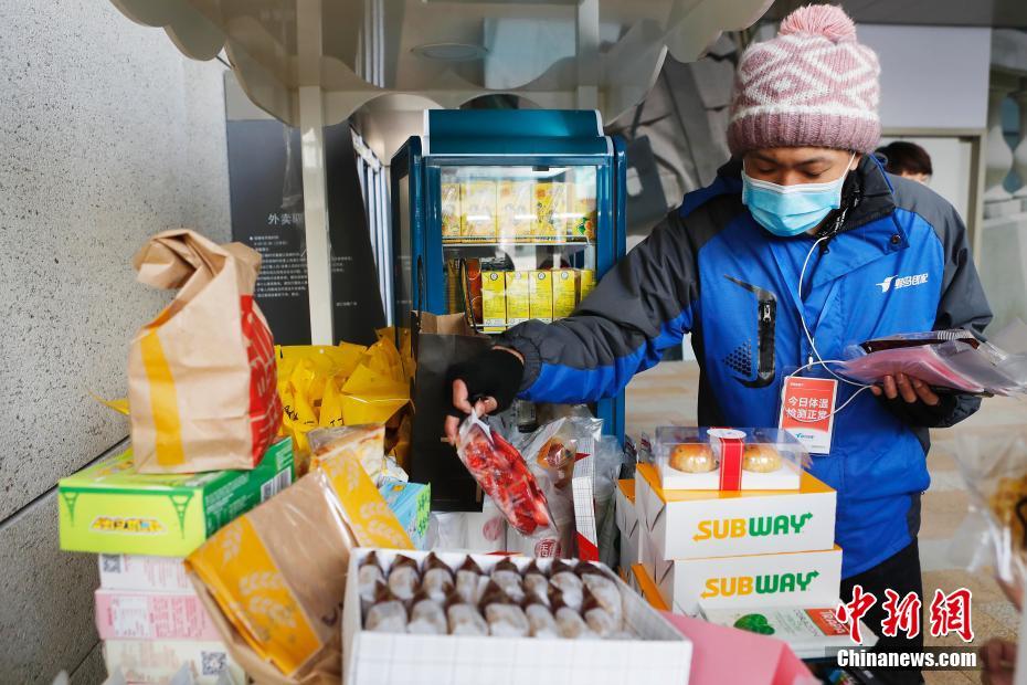 2月27日、スイーツを取るデリバリー配達員の男性（撮影?殷立勤）。