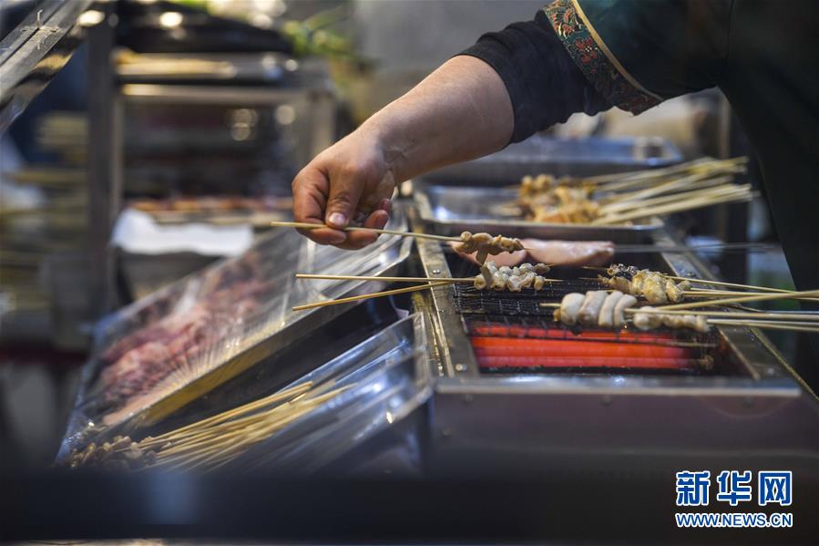 3月16日、ホータンナイトバザール環湖店で、串焼きを作る屋臺の店主（撮影? 趙戈）。