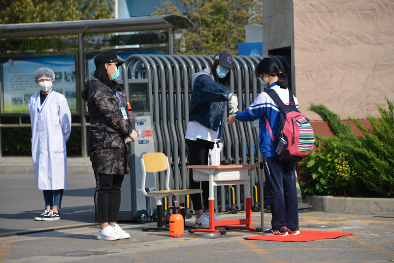 資料寫真、北京市昌平二中回竜観キャンパスの校門で體溫測定を受ける學生（畫像提供?北京教育ニュースセンター）。