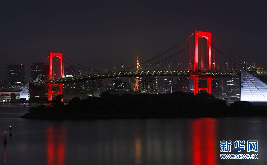 「東京アラート」発動にともない、ライトアップの色が虹色から赤色に変わったレインボーブリッジ（寫真提供?新華社、共同通信社）。