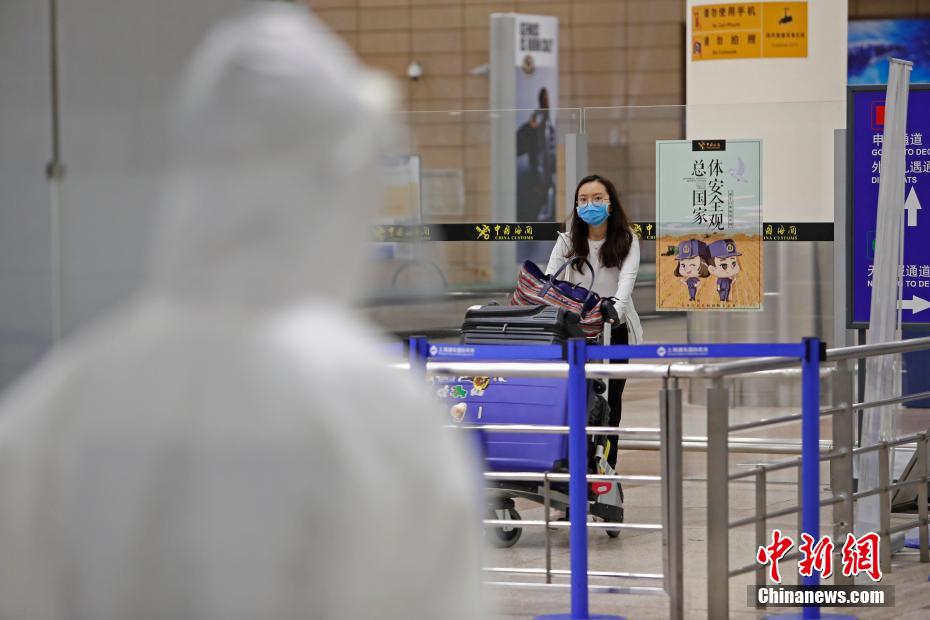 カートを押しながら上海浦東國際空港の到著ロビーに姿を現した米國からの旅客（撮影?殷立勤）。