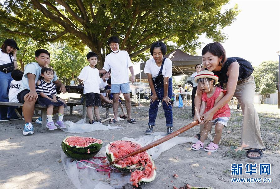 8月11日、東京?葛西臨海公園で、スイカ割りを楽しむ子供と保護者（寫真提供?新華社、共同通信社）。