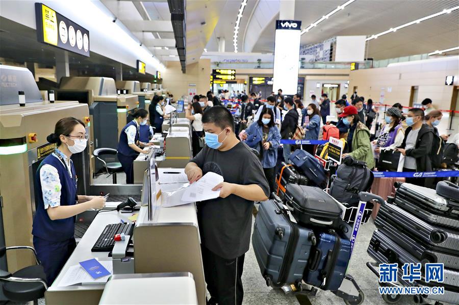 9月21日、海南航空が運(yùn)航する英國(guó)行チャーター機(jī)HU7953便に搭乗するため、重慶江北國(guó)際空港ターミナルビルの指定エリアでチェックイン手続きをする留學(xué)生たち（畫像提供?重慶空港集団）。