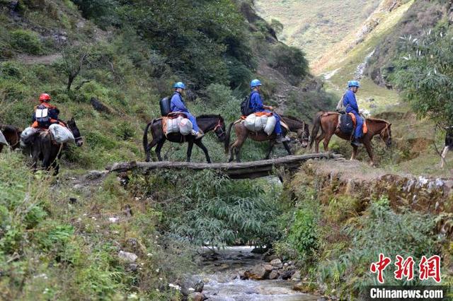 馬に跨り木の橋を渡り無人區(qū)に入る4人の電気保安管理員（撮影?張浪）。