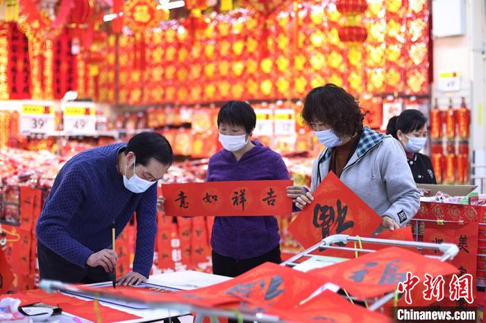 買い物客に無料で「春聯」や「福」の字を書く書道家（撮影?泱波）。