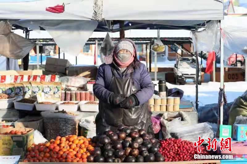 しっかり著込んで東北名物の凍果を売る漠河市の露店経営者（撮影?王景陽(yáng)）。