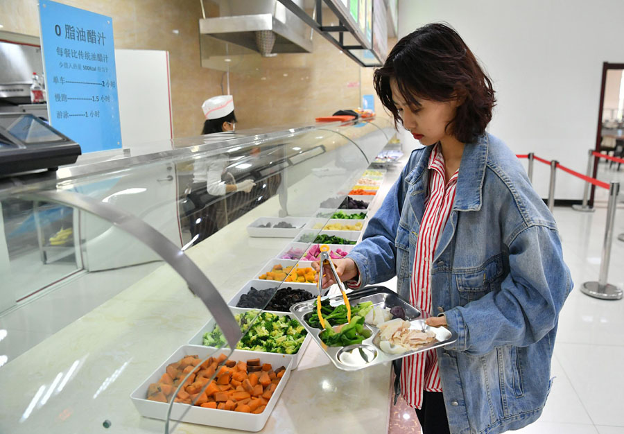 4月1日、長春中醫(yī)薬大學(xué)の食堂で、ヘルシーな料理を選ぶ女子大生（寫真著作権はCFP視覚中國が所有のため転載禁止）。