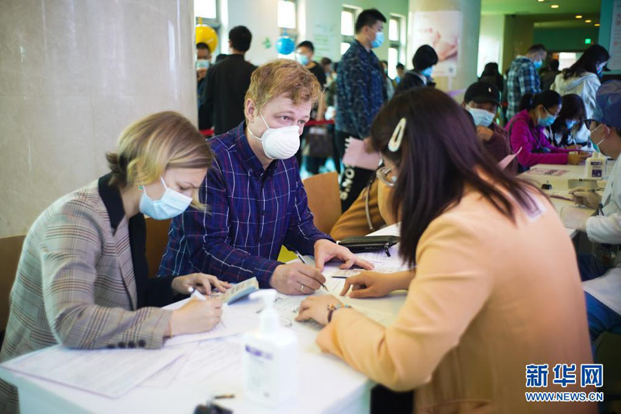 4月15日、北京経済開発區の新型コロナワクチン接種會場で、接種前に個人情報を登録する外國人。この接種會場では、これまでに、外國人500人以上への接種を完了（撮影?彭子洋）。