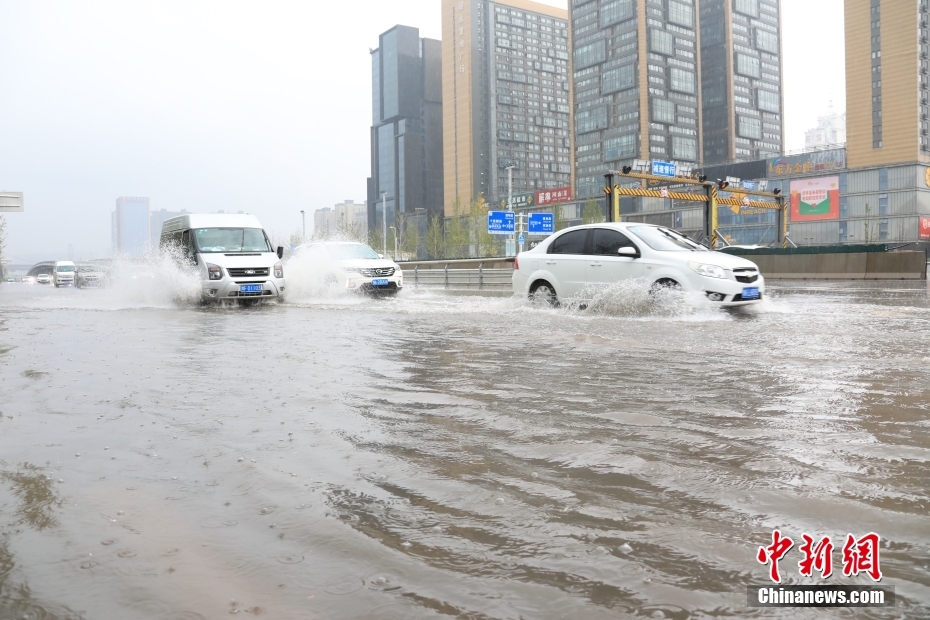 鄭州市市街地で、冠水した道路を走行する車両（撮影?闞力）。