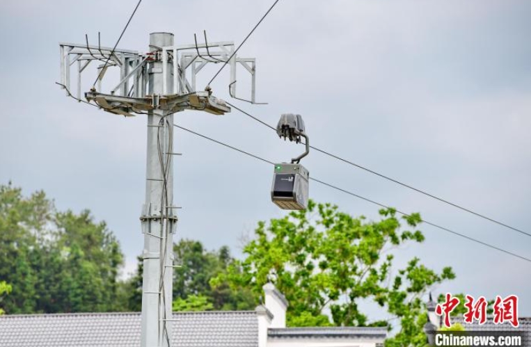 4月14日、江西省贛州市安遠県鶴子鎮陽佳村で、農産物を積載したスマート物流配送快速ラインのロープウェイで移動する「往來ロボット」（撮影?朱海鵬）。