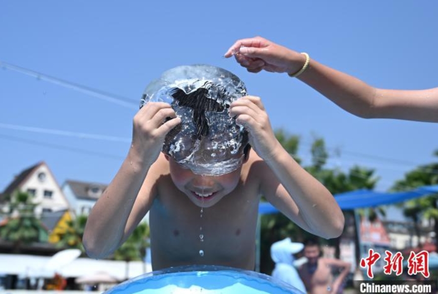 暑気払いに氷と戯れる子供（撮影?陳超）。