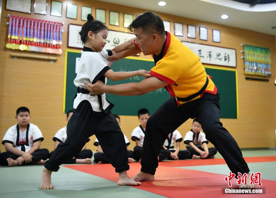 8月3日、河北省石家荘市にあるスポーツトレーニング施設(shè)で、組み手のやり方を子供に指導(dǎo)する「カンフー格闘技」伝承者の楊興コーチ（寫真右、撮影?翟羽佳）。