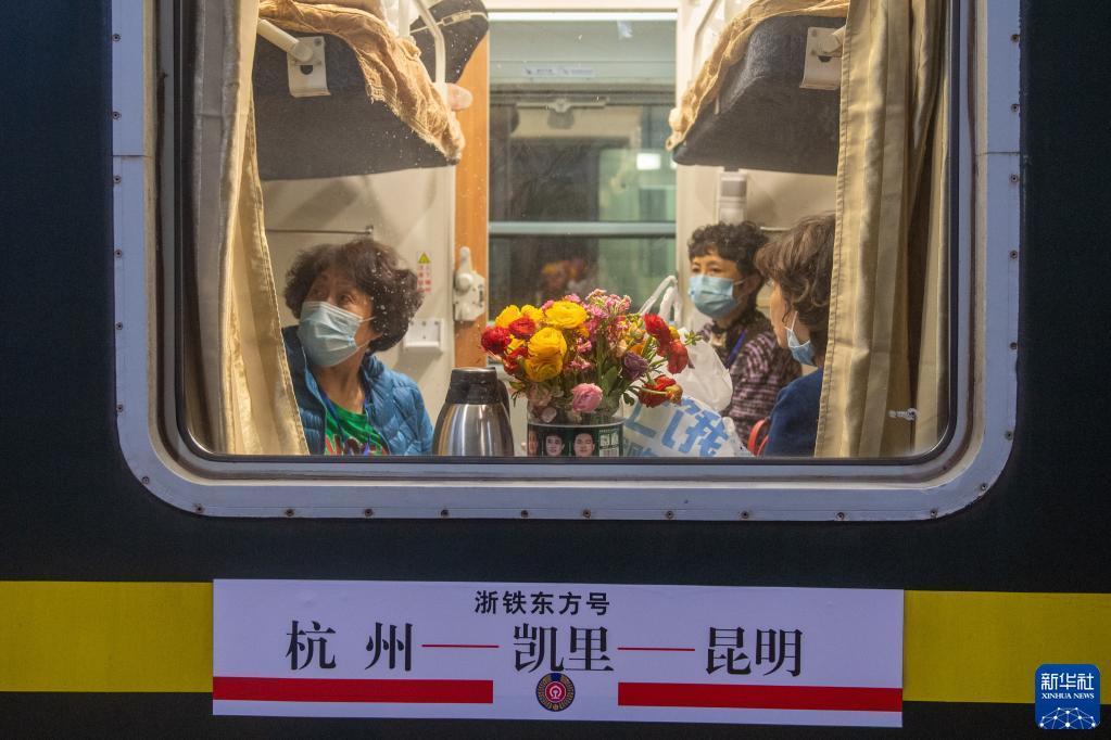 乗車後、自ら持參した花を座席に飾る乗客（3月10日撮影?江漢）。