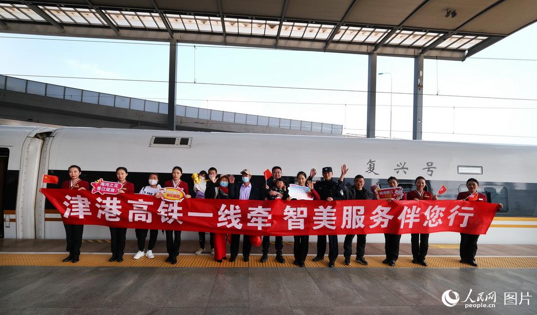 天津西駅と香港西九竜駅を結ぶ高速鉄道列車G305號の出発前に天津西駅のホームで記念寫真を撮影する乗務員と乗客（4月1日撮影?楊寶森）。