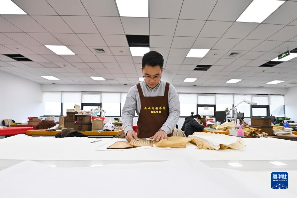 山西省図書館古書修復センターで古書に當て紙を施す程文濤さん（4月21日撮影?楊晨光）。