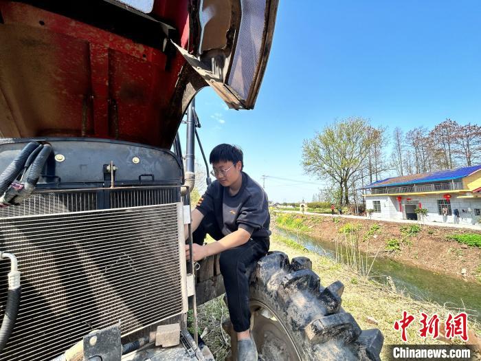 3月28日、自宅のエビ養殖水田で農業機械の點検整備を進めている00後（2000年代生まれ）の虢宇さん。（撮影?曹盈）